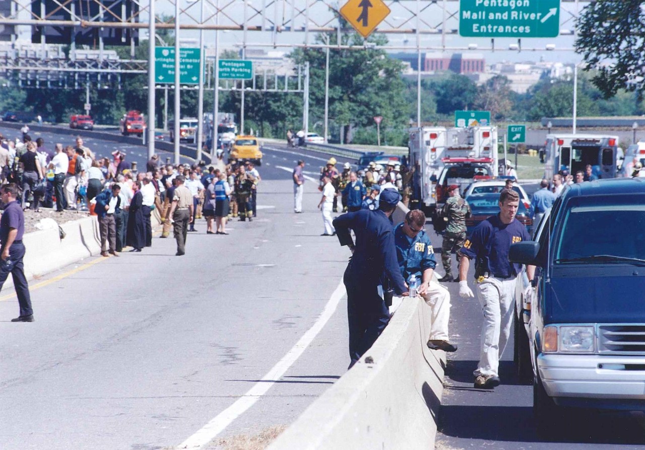 Pentagon employees, law enforcement, and emergency response teams gather on VA-110 near the North Parking Lot, 11 September 2001