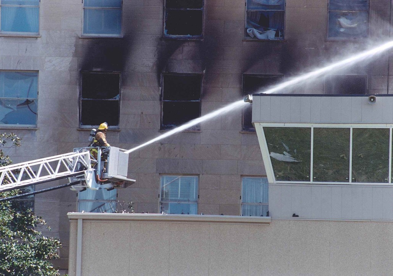 A firefighter works to put out fires burning in the E Ring of the Pentagon near the heliport control tower, 11 September 2001