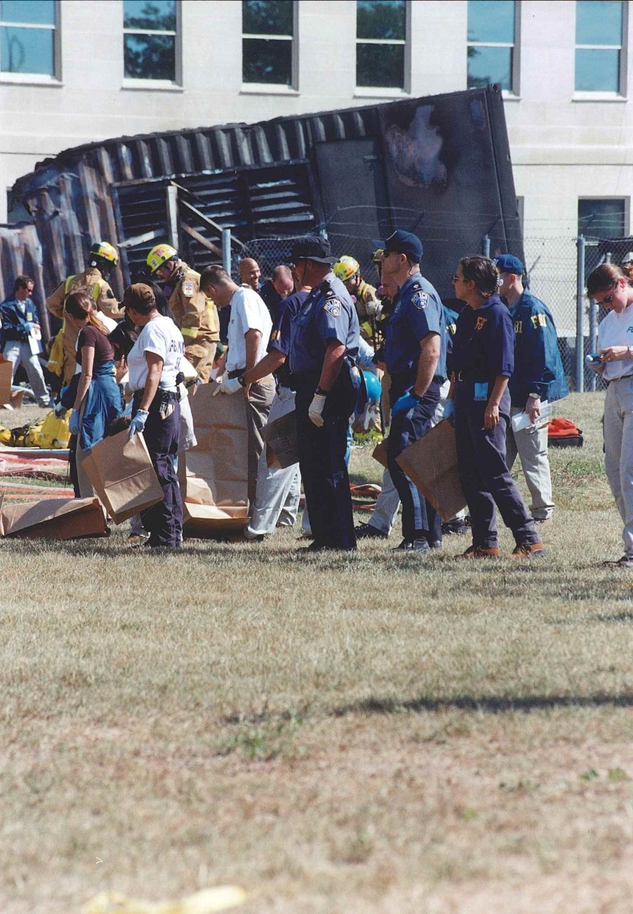 Volunteers and FBI personnel perform evidence sweeps near the point of impact, 11 September 2001