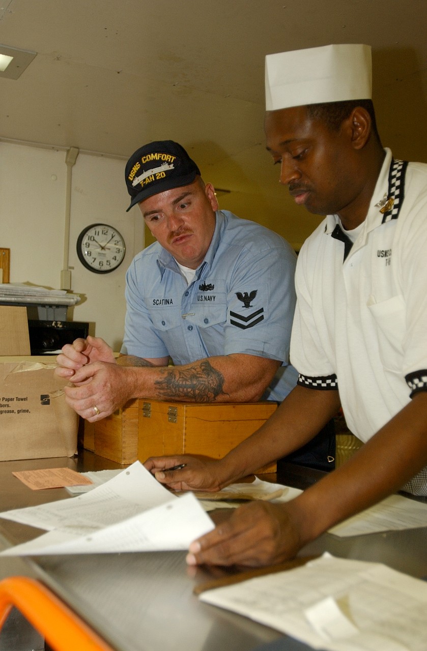 Two Petty Officers aboard USNS COMFORT (T-AH 20) work on the meal plan to provide 24-hour support to police officers, firemen, and volunteers working at Ground Zero in New York City, 19 September 2001