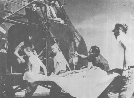 Image of Battle Casualty Still Receiving Dextrose Is Carried to a Helicopter for Transfer to USS REPOSE (AH 16), the Navy Field Hospital Ship off the Coast of Vietnam