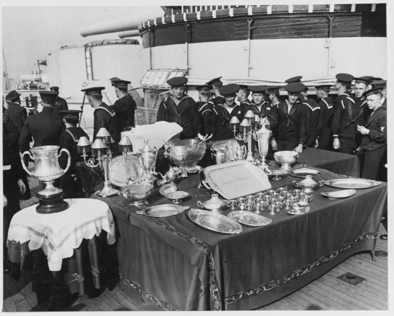 Crewmen examine the silver service following the presentation ceremony, 23 April 1919. (Naval History and Heritage Command Photograph NH 57686)
