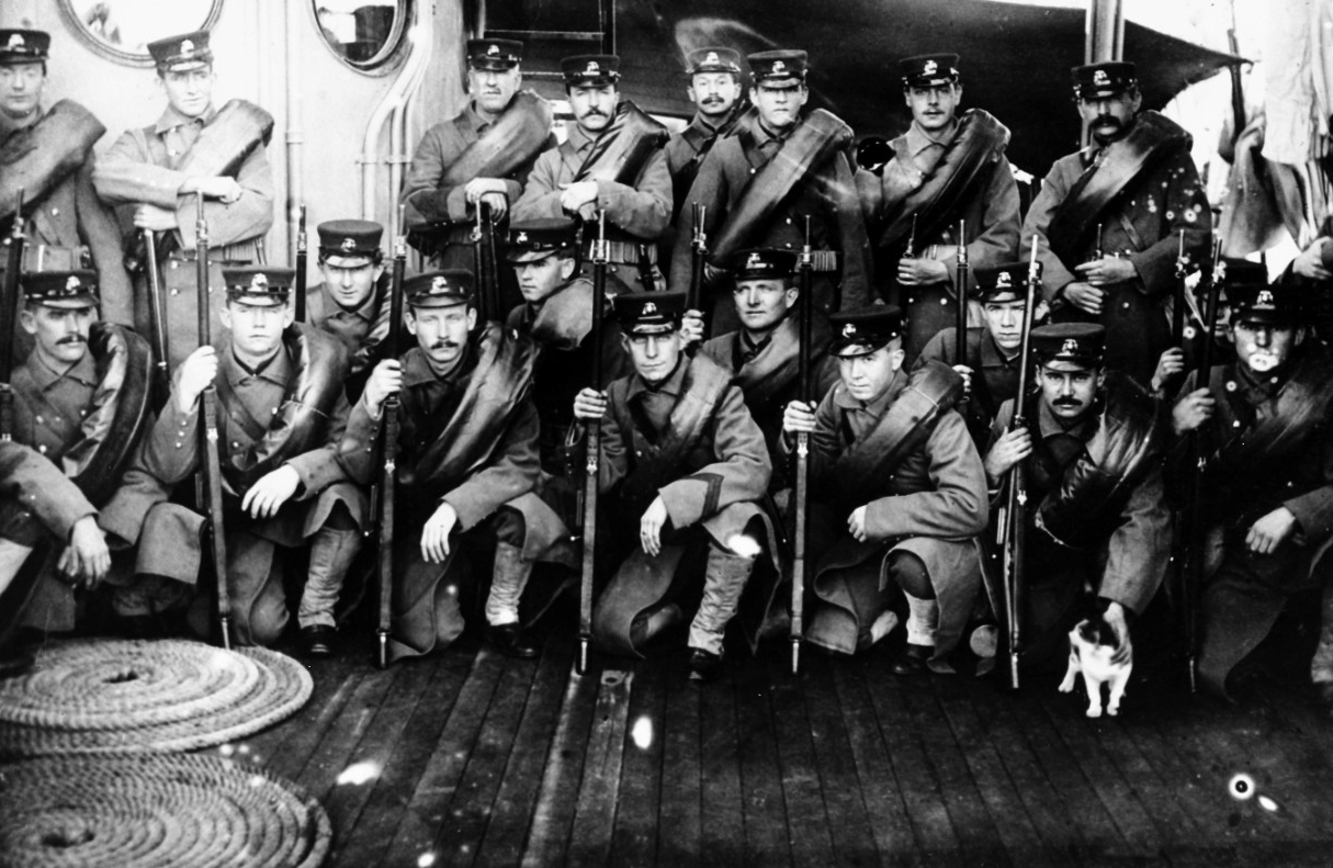 Baltimore’s Marine Guard in heavy marching order, during her Asiatic Fleet deployment, circa 1904-1906. They were equipped for winter expeditionary party duty, with horseshoe rolls containing their blankets rolled in rubber ponchos. They are arme...