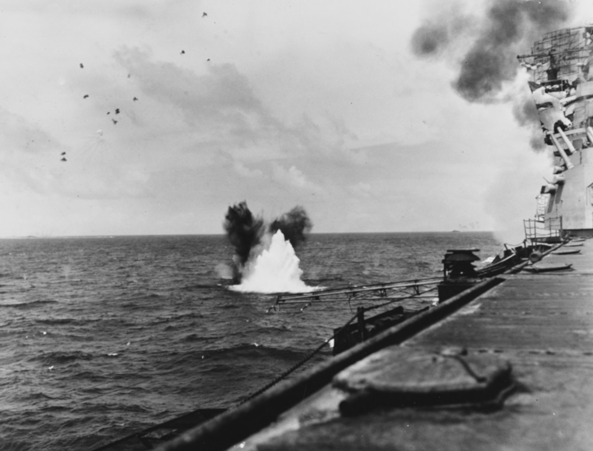 A bomb from a Japanese plane explodes close aboard Bunker Hill in the opening phases of the battle of the Philippine Sea, 19 June 1944. (Naval History and Heritage Command Photograph NH 74281)