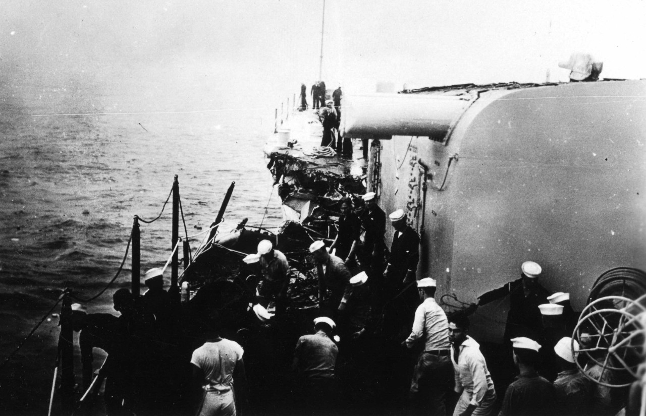 Chicago’s sailors, wearing a variety of uniforms ranging from dungarees to undress whites and blues, labor to save their ship, the expression on some of the men’s faces reflecting the gravity of the situation. The ship’s main battery gunnery prowess is reflected by the “E” on Turret I with a hash mark beneath it (R).  (U.S. Navy Photograph, National Archives and Records Administration, Still Pictures Branch, College Park, Md.)