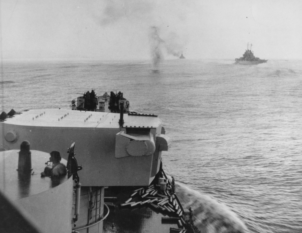 A Japanese plane downed by TF 39’s anti-aircraft fire hits the water ahead of Columbia as she steams in column formation with her sister ships from Cruiser Division 12 during the attack on Bougainville. The foreground is filled with one of the sh...