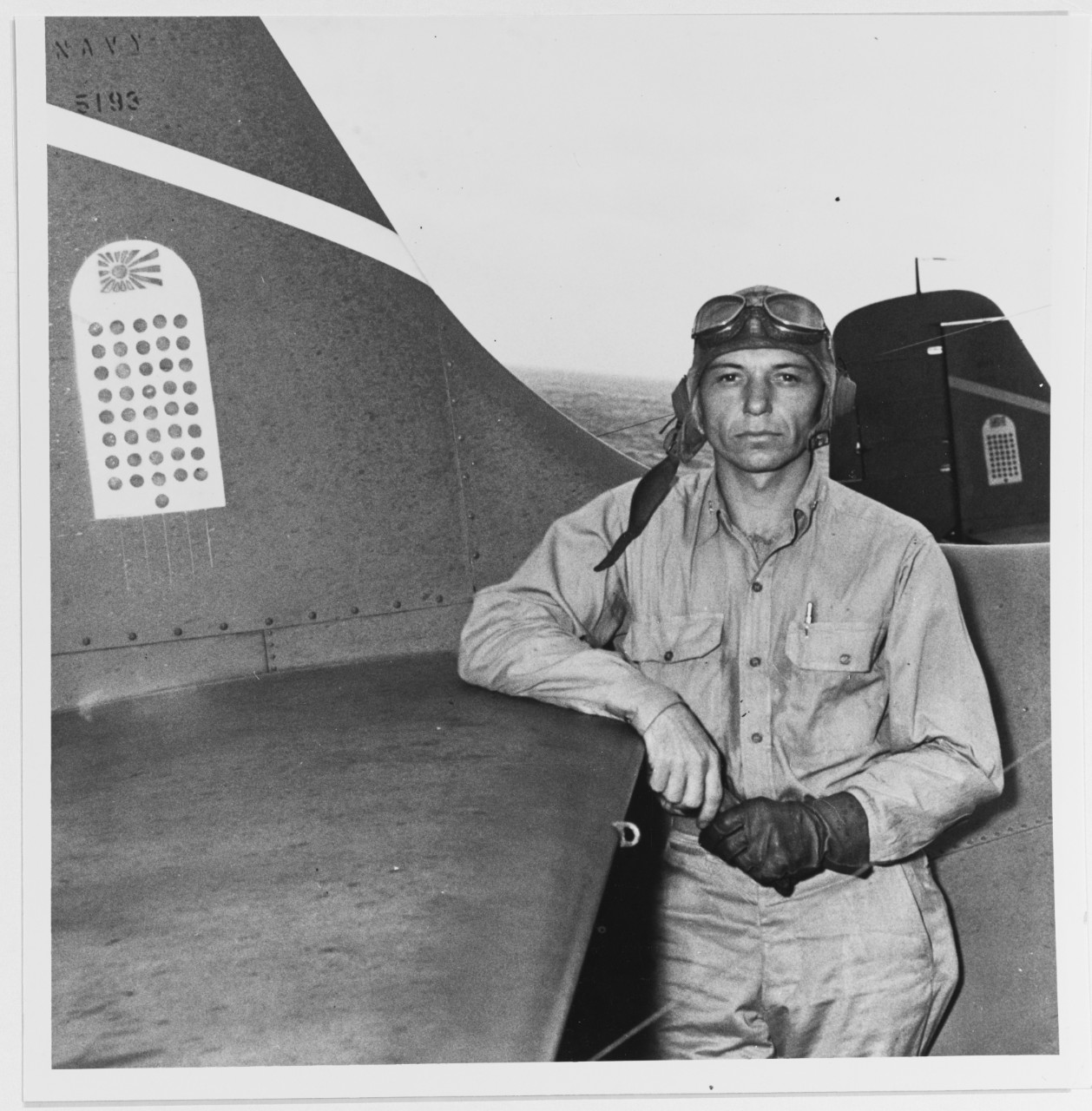 Machinist Donald E. Runyon of VF-6 leans on his F4F-4 Wildcat (BuNo. 5193) on board Enterprise, 10 September 1942. The tombstone on his plane’s tail contains 41 Rising Sun symbols for the Japanese aircraft that the squadron claims to shoot down by this point in the war. Runyon is eventually credited with 11 kills, and receives the Navy Cross and Distinguished Flying Cross. (U.S. Navy Photograph 80-G-11103, National Archives and Records Administration, Still Pictures Branch, College Park, Md.)