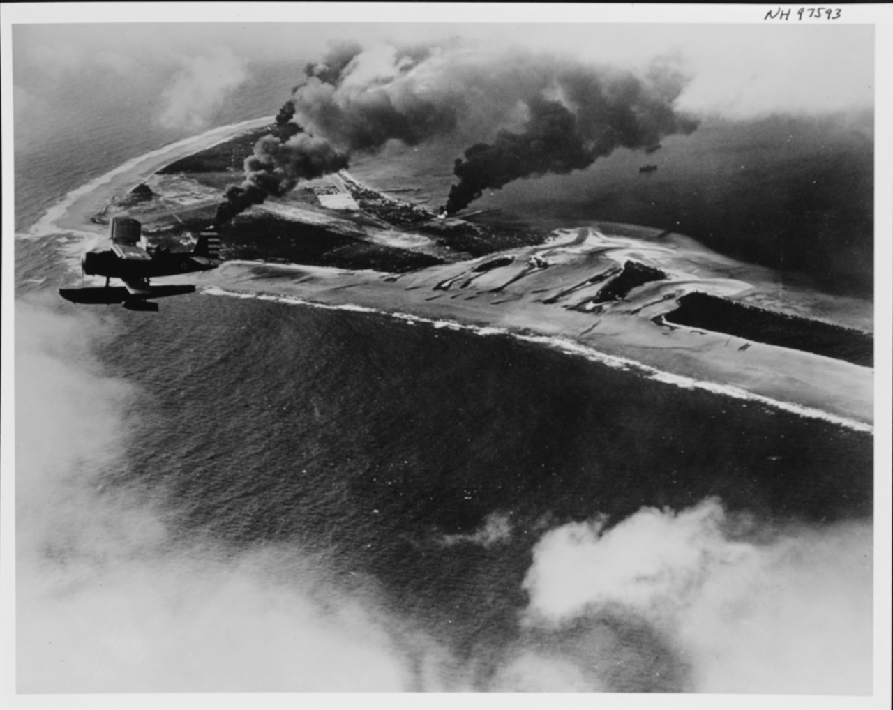 An SOC-1 Seagull of Cruiser Scouting Squadron (VCS) 5 observes the fall of shot as Northampton and Salt Lake City pound Wotje, 1 February 1942. Fires rise from several Japanese positions, including an ammunition dump and a fuel dump. (U.S. Navy Photograph NH 97593, Naval History and Heritage Command)