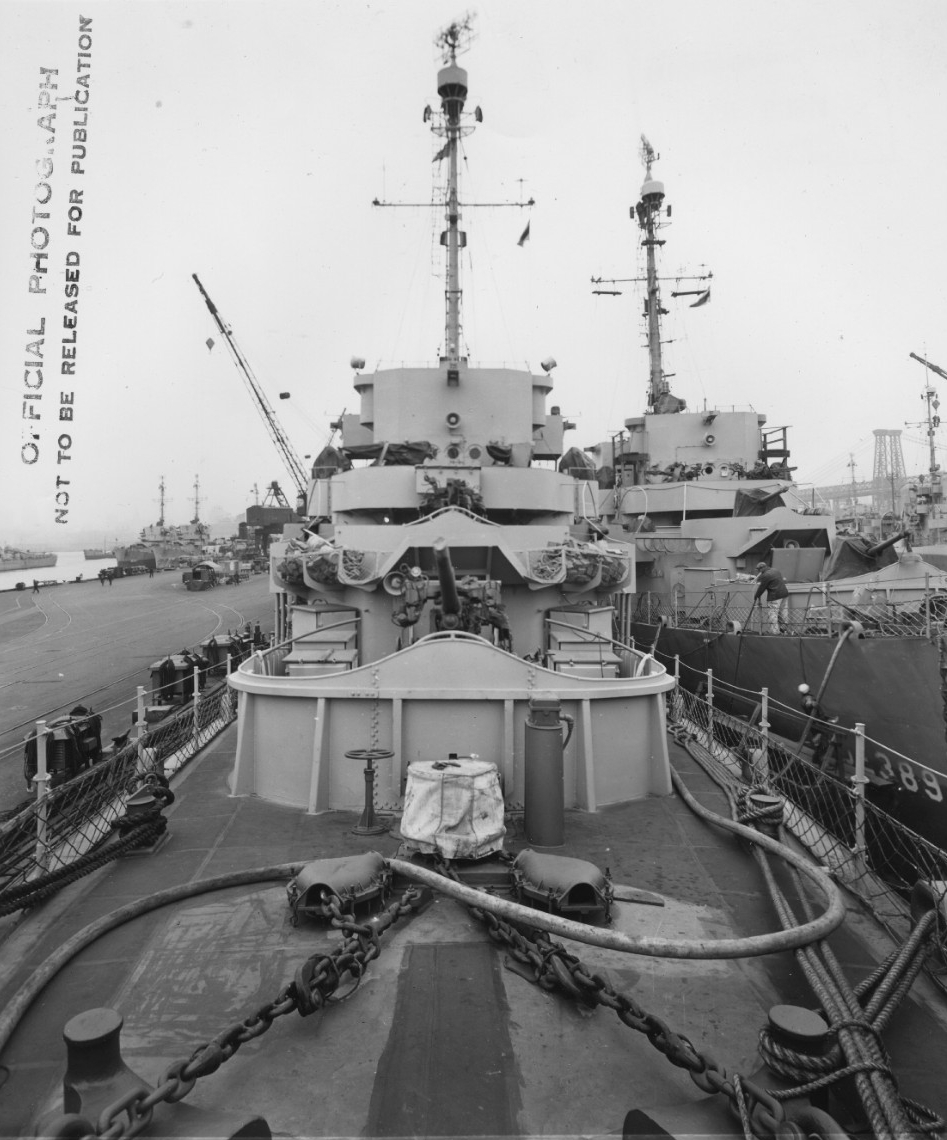 Looking aft from Fiske’s “foc’sle,” 29 March 1944, New York Navy Yard, with Durant (DE-389) moored alongside (R). Note Fiske’s forward 3-inch/50 caliber guns with their ready service ammunition boxes (the larger boxes visible just behind those hold hedgehog projectiles). Also note two 20-millimeter mounts, floater net stowage, and details of the bridge. (U.S. Navy Bureau of Ships Photograph BS 65725, National Archives and Records Administration, Still Pictures Division, College Park, Md.)