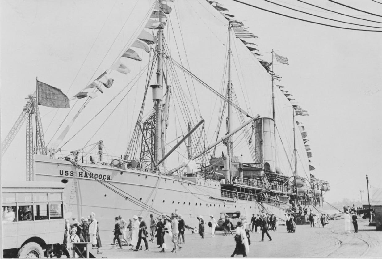 Hancock dressed with flags at the Philadelphia Navy Yard, Pa., 28 June 1919. Note the men and women strolling on the waterfront, and the bus at left. (Naval History and Heritage Command Photograph NH 53624) 