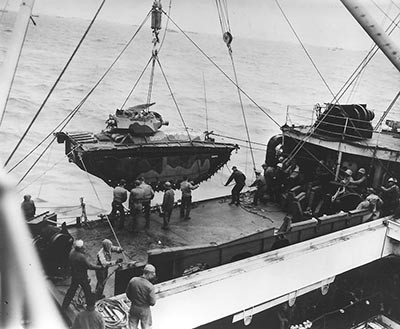 Men hoist out No. 835, a marine landing vehicle tracked (LVT), from Hansford (APA-106), February 1945. LVT(A)4s such as this vehicle, armed with M3 75 millimeter howitzers or Canadian Ronson flamethrowers, support the marines fighting the Japanese on Iwo Jima. 