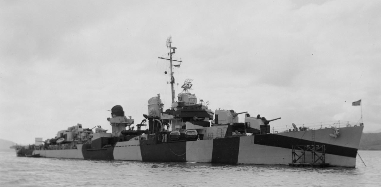 Starboard view of Heermann at anchor at the conclusion of her overhaul at Nouméa, 9 August 1944, wearing what appears to be a fresh Measure 32 camouflage. Note painting stage forward, and movie screen erected on the fantail. (U.S. Navy Bureau of Ships Photograph BS 126341, National Archives and Records Administration, Still Pictures Division, College Park, Md.)