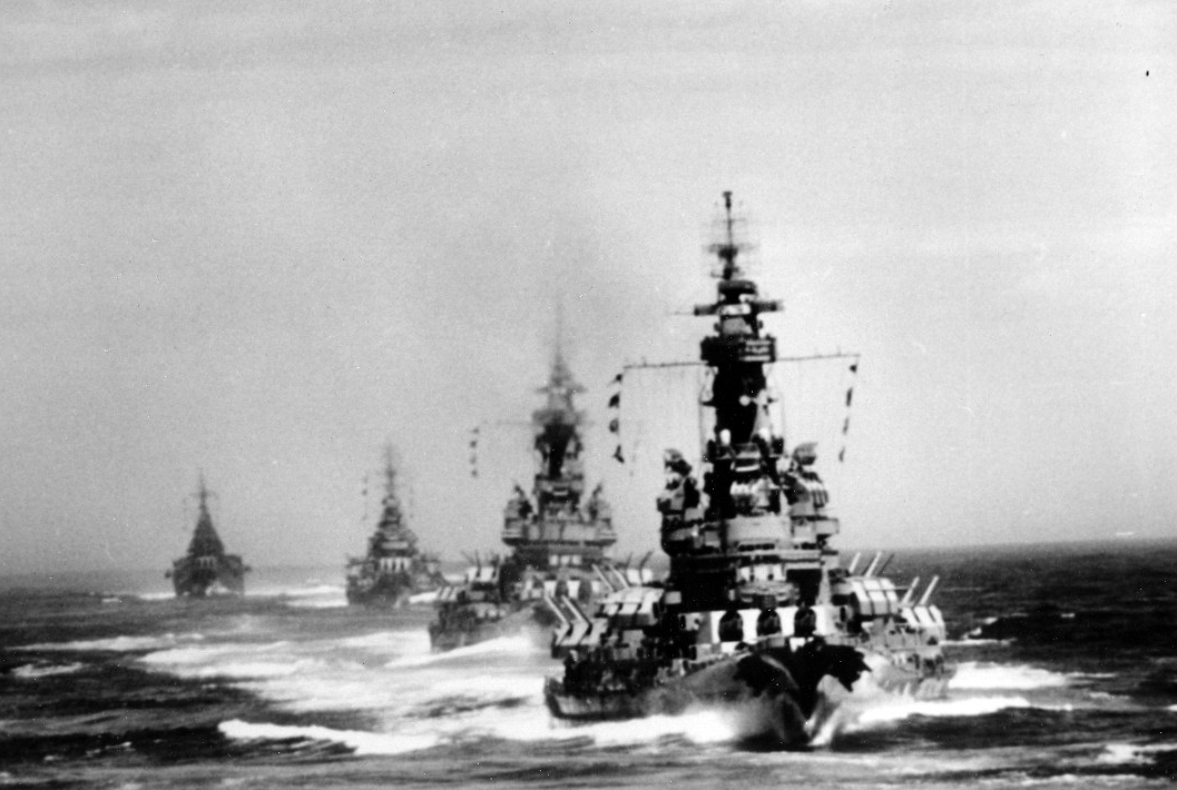 Ships steam in column as they prepare to shell the iron works at Kamaishi, Japan, 14 July 1945. Indiana is the nearest ship, as seen from South Dakota, followed by Massachusetts, Chicago, and Quincy. (U.S. Navy Photograph 80-G-490143, National Ar...