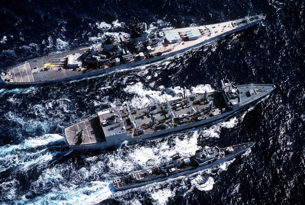 Kansas City, center, provides underway replenishment to battleship New Jersey (BB-62), top, and guided missile destroyer Buchanan (DDG-14), 12 August 1983. (U.S. Navy Photograph DN-ST-83-10377, National Archives and Records Administration, Still Pictures Division, College Park, Md.)