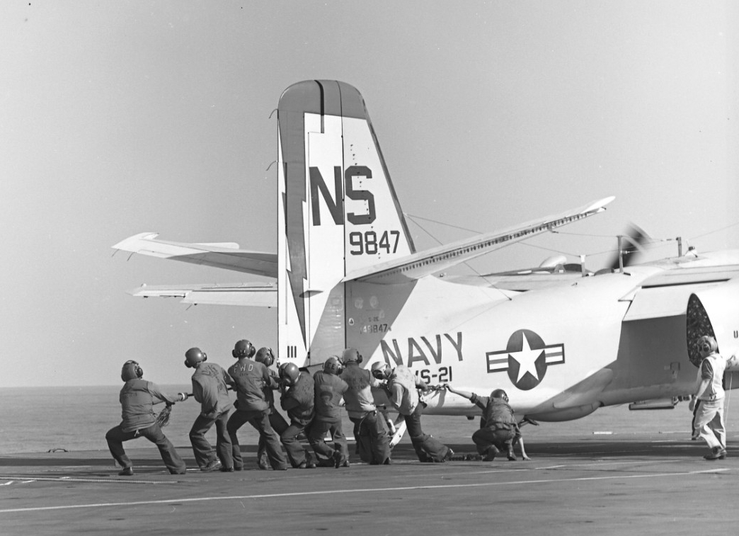 Kearsarge continues to serve in the Vietnam War and a working party labors to move an S-2E Tracker (BuNo 149847) of VS-21 onto a catapult to launch for Operation Beach King while the ship steams in the South China Sea, 19 July 1969. (Naval History and Heritage Command Photograph UA 456.01)