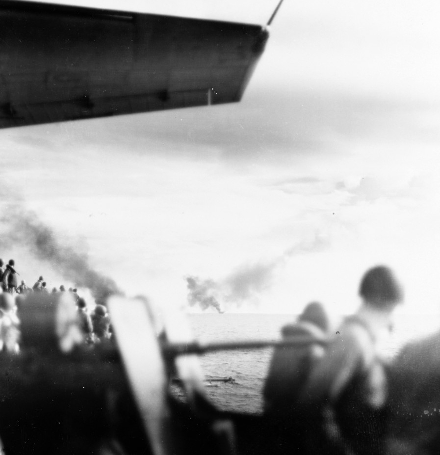 Sailors on board Kitkun Bay watch in horror as Gambier Bay burns and falls behind, 25 October 1944. (U.S. Navy Photograph 80-G-287512, National Archives and Records Administration, Still Pictures Division, College Park, Md.)