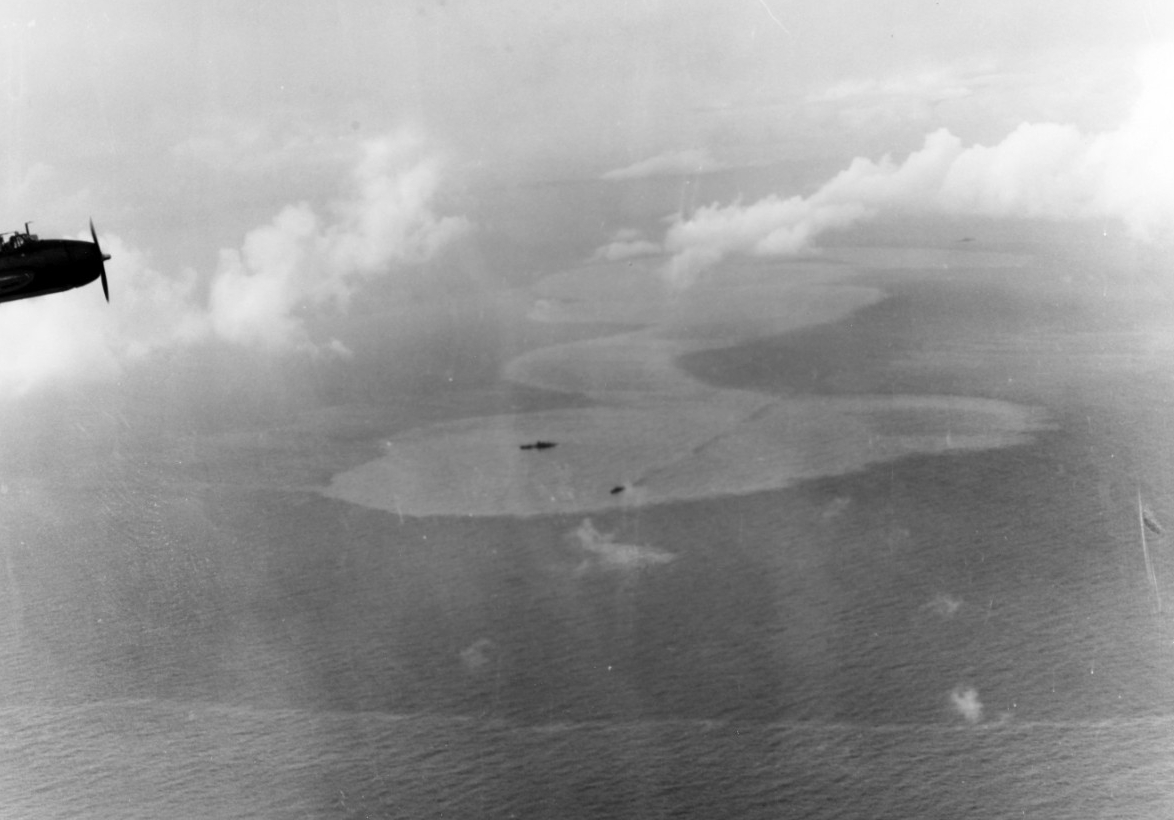 A Japanese heavy cruiser, possibly Chikuma, lies dead in the water, as a destroyer stands by to render assistance, 25 October 1944. An Avenger from one of the carriers, likely the wingman of the plane that takes the picture, flies in the upper left. A rapidly spreading oil slick is mute testimony to the damage inflicted on the cruiser. (U.S. Navy Photograph 80-G-287538, National Archives and Records Administration, Still Pictures Division, College Park, Md.)