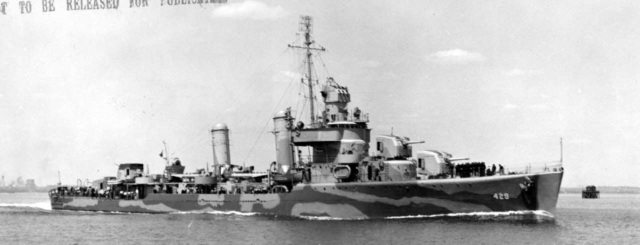 With a bone-in-teeth and her crew at quarters, Livermore stands out of Boston, 11 May 1942, painted in disruptive camouflage. Note that she has received a search radar at the top of her foremast but has not yet received fire control radar atop her Mk. 37 director. While the number of 5-inch mounts has been cut to four, she now carries six 20-millimeter Oerlikons, and much tophamper has been reduced aft. (U.S. Navy Bureau of Ships Photograph BS-29801, National Archives and Records Administration, Still Pictures Division, College Park, Md.)