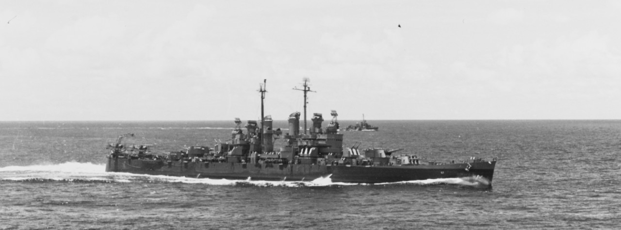 Montpelier, wearing a two-color camouflage (the dividing line following the horizon instead of the sheer of the main deck), with a dazzle-painted Fletcher-class destroyer in the distance, maneuvers while en route to Saipan, 11 June 1944; as seen from the escort carrier Gambier Bay (CVE-73). (U.S. Navy Photograph 80-G-243381, National Archives and Records Administration, Still Pictures Division, College Park, Md.)