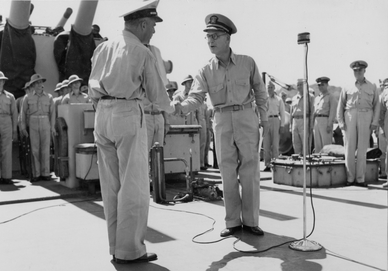 Rear Adm. Hayler (center) relieves “Tip” Merrill (left), 26 March 1944, while Montpelier’s marine detachment stands at attention under the guns of Turret IV. Note the marines wearing Hawley sun helmets. (U.S. Navy Photograph 80-G-232134, National...