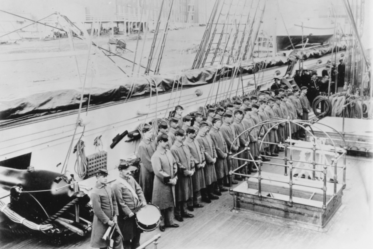 The sloop-of-war’s marine guard parades on deck while she lies moored at Portsmouth, 1885. Note the bugler and the drummer on the left, and the IX-inch smoothbore gun behind them. (Naval History and Heritage Command Photograph NH 58909)