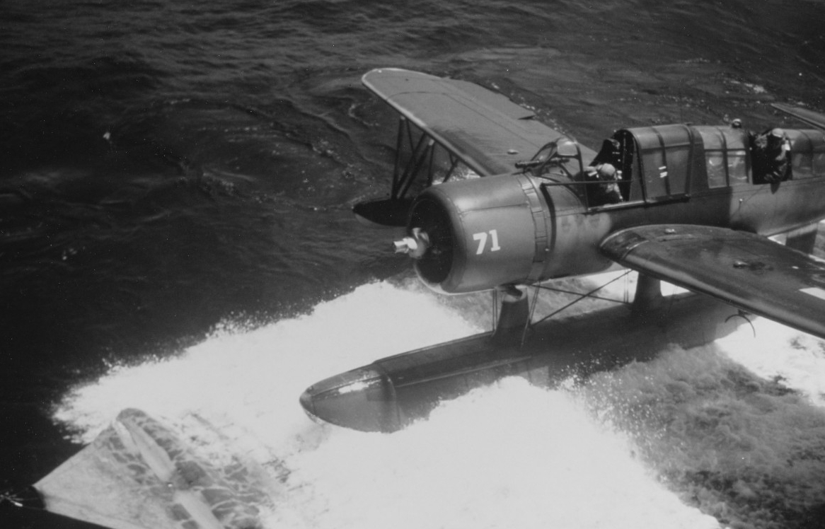 One of the ship’s Kingfishers taxis alongside the ship onto the recovery mat, circa 1944. The picture demonstrates the danger of the maneuver, and note that the pilot leans out of the cockpit. (U.S. Navy Photograph 80-G-K-1954, National Archives ...