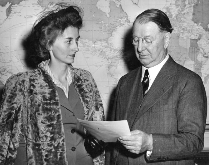 Secretary of the Navy William F. (Frank) Knox meets Mrs. Virginia S. Ringness, widow of the late Lt. Ringness, 20 October 1943. (U.S. Navy Photograph 80-G-43409, Still Pictures Branch, National Archives and Records Administration).