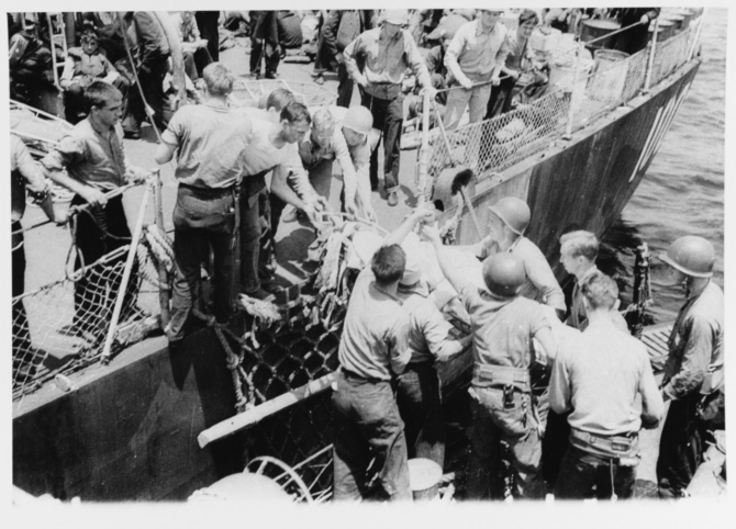 Sailors transfer some of Evans’ wounded crewmen from Ringness (left) to PCER-855 off Okinawa, 11 May 1945. They are photographed from on board the patrol rescue escort. (U.S. Navy Photograph 80-G-331077, copy of the National Archives and Records Administration photograph held by the Photographic Section, Naval Heritage and History Command).