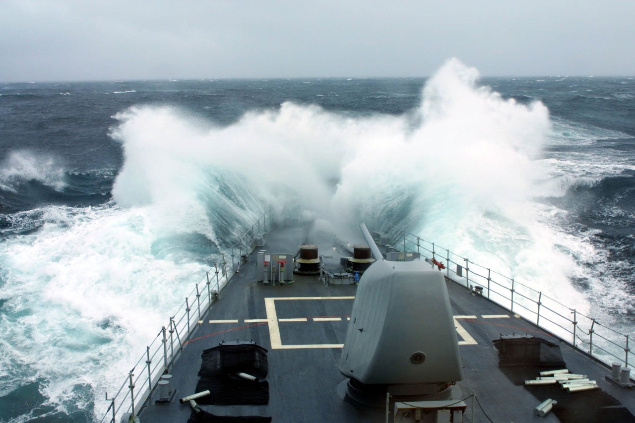 Heavy swells once again pound Spruance as she takes part in Northern Lights, August–October 2003. The foul weather evidently interrupts the gun shoot, as evidenced by the spent casings rolling about the deck. (Spruance (DD-963) Command History Re...