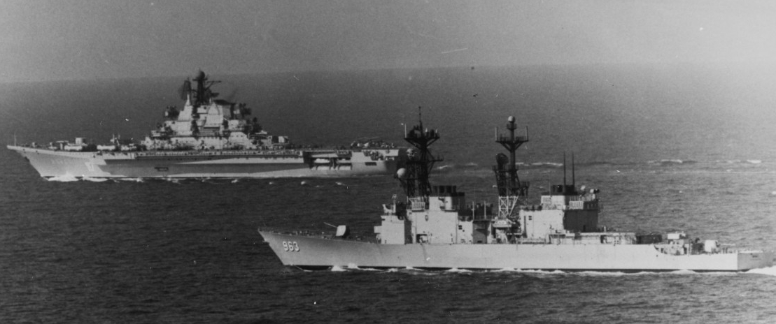 Spruance (right) keeps an eye on Minsk (left) as the Soviet aircraft carrier passes through Tunisian waters, March 1979. The ships steam in dangerous proximity during the tense encounter. (Naval History and Heritage Command Photograph NH 1174867)