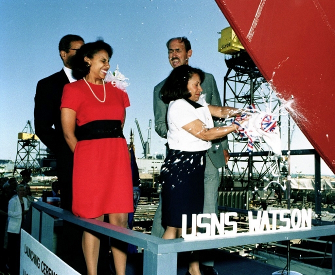 Mrs. Gail Berry West, sponsor of Watson, breaks the traditional bottle of champagne across the ships' bow on 26 July 1997 to officially launch the vessel at the National Steel & Shipbuilding Co., San Diego, Calif. In attendance is her husband, former Secretary of the Army Togo D. West Jr.; her daughter, Ms. Hilary West, Maid of Honor and Richard A. Vortmann, NASSCO President. (U.S. Department of Defense photo DN-ST-01-00408).
