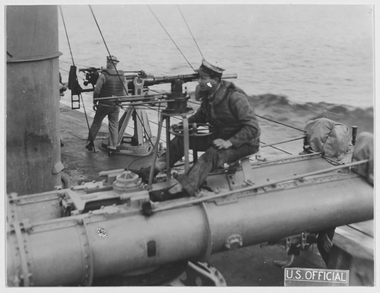 A Whipple torpedoman training a twin 18-inch torpedo tube mount installed just aft of the ship's after smokestack, 18 June 1918. Note the telescopic sight on the torpedo tube mounting, and the 6-pounder gun in the background. (Naval History and Heritage Command Photograph NH 41761)