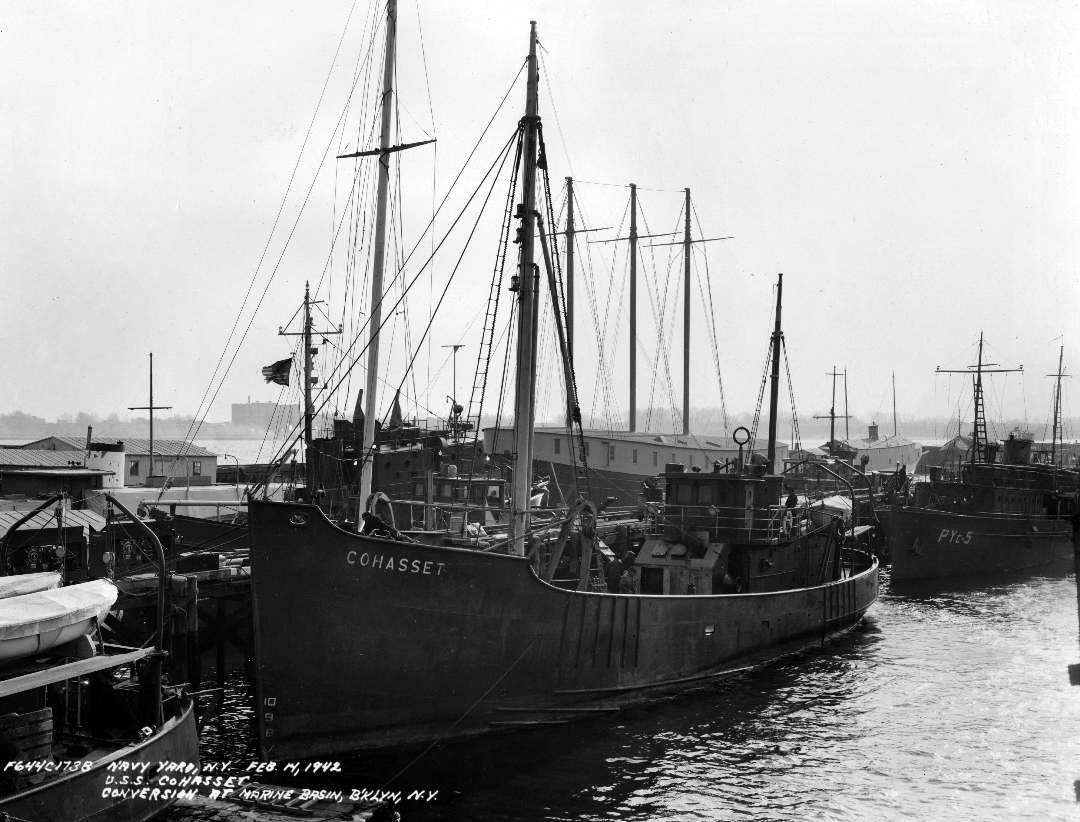 Cohasset, undergoing conversion at the Marine Basin, Brooklyn, N.Y., 14 February 1942, with coastal patrol yacht Onyx (PYc-5) (ex-Pegasus) astern and Cohasset’s sistership, Lynn, at far left in foreground, also undergoing transformation from trawler to patrol vessel (YP-388). (U.S. Navy Bureau of Ships Photograph BS-32348, National Archives and Records Administration, Still Pictures Branch, College Park, Md.)