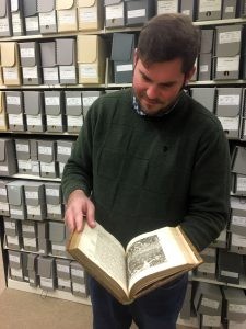 170410-N-FJ200-001 WASHINGTON (April 10, 2017) Naval History and Heritage Command Special Collections Reference Librarian Tim Bostic reads a page from one of the numerous rare books maintained in the Navy Department Library. (U.S. Navy photo by Mass Communication Specialist 1st Class Clifford L. H. Davis/Released)