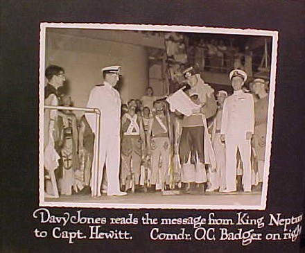 Davy Jones reads the message from King Neptune to Capt. Hewitt. Comdr. O.C. Badger on right.