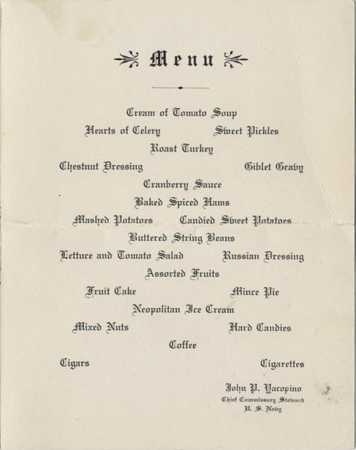 Menu: Cream of Tomato Soup, Hearts of Celery, Sweet Pickles, Roast Turkey, Chestnut Dressing, Giblet Gravy, Cranberry Sauce, Baked Spiced Ham, Mashed Potatoes, Candied Sweet Potatoes, Buttered String Beans, Lettuce and Tomato Salad, Russian Dressing, Assorted Fruits, Fruit Cake, Mince Pie, Neopolitan Ice Cream, Mixed Nuts, Hard Candies, Coffee, Cigars, Cigarettes. John P. Yacopino, Chief Commissary Steward, U.S. Navy.