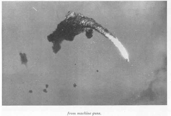 Japanese plane bursts into flames after a direct hit by AA fire. White dots indicate tracer fire from machine guns.