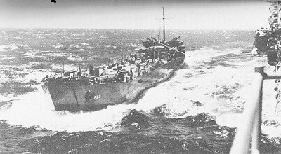 Image of transferring bombs from LST to the carrier Hancock at sea.
