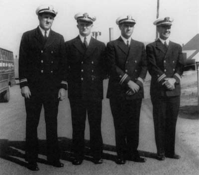 Photo of Lieutenant (jg) Terry, Ensign Riordan, Lieutenant Gus Greanias, and Lieutenant Bob Wallace.