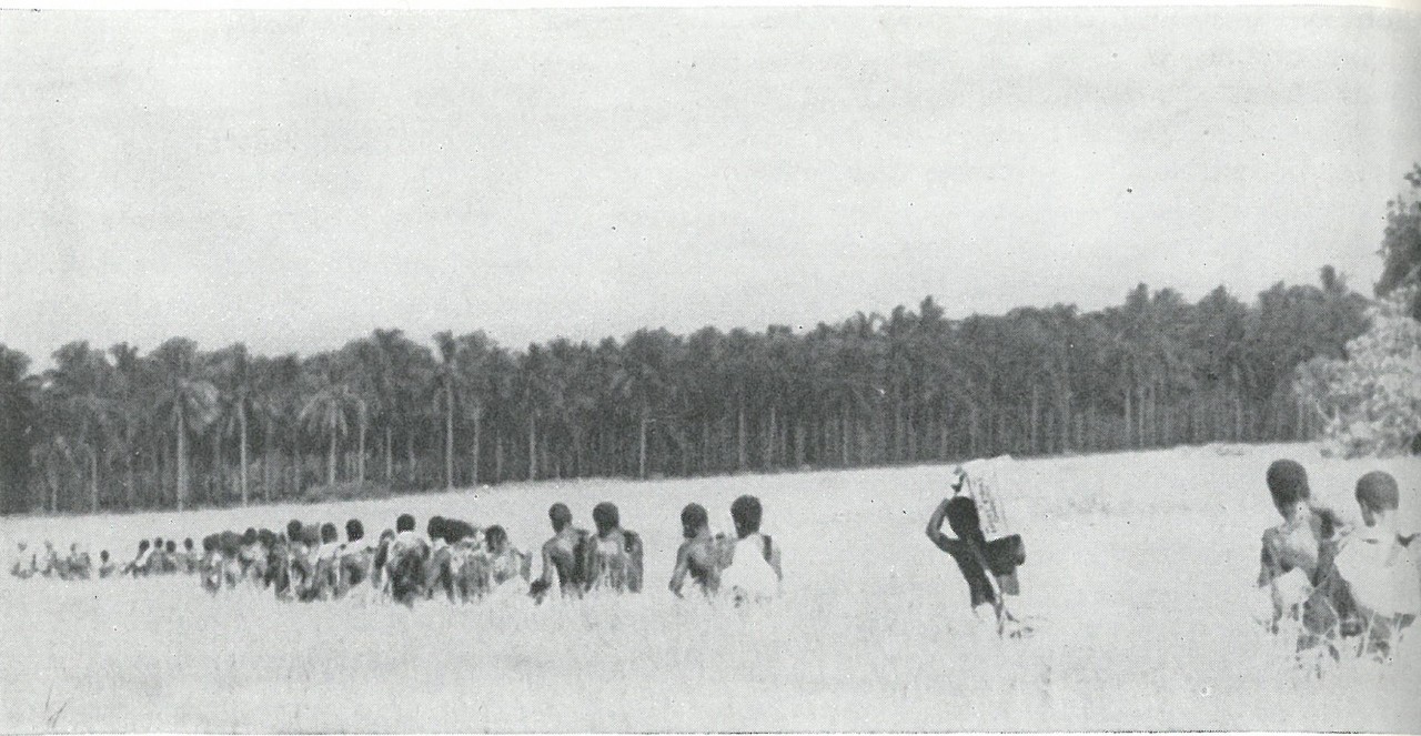 CARLSON'S RAIDERS ON THE MARCH, at extreme left, assisted by native bearers who helped make possible the long November patrol outside the perimeter by the 2d Raider Battalion.