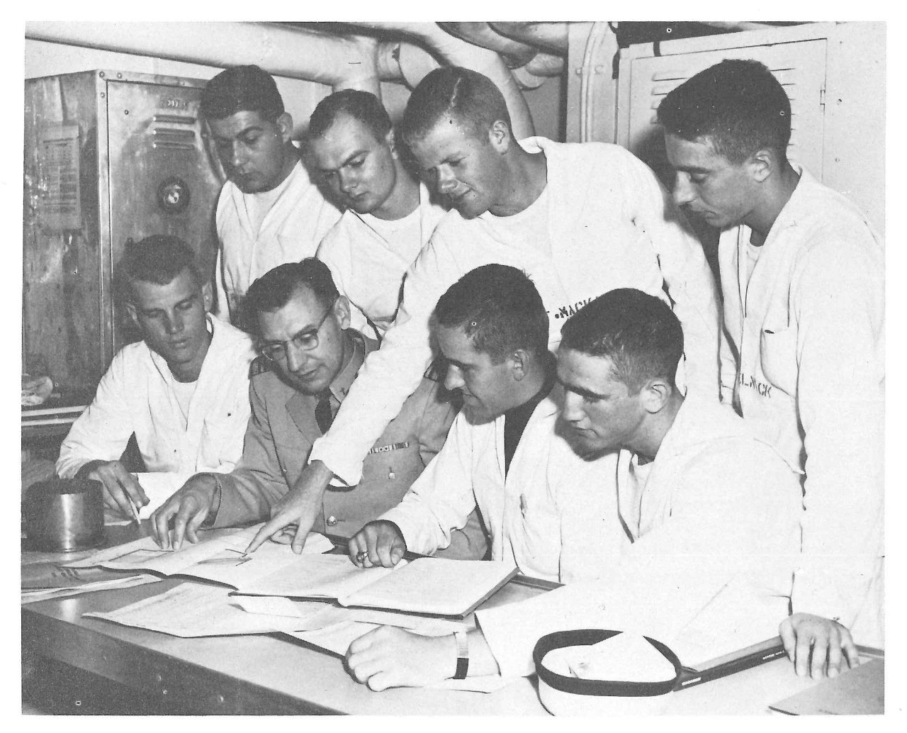 Navy seamen viewing documents with an instructor