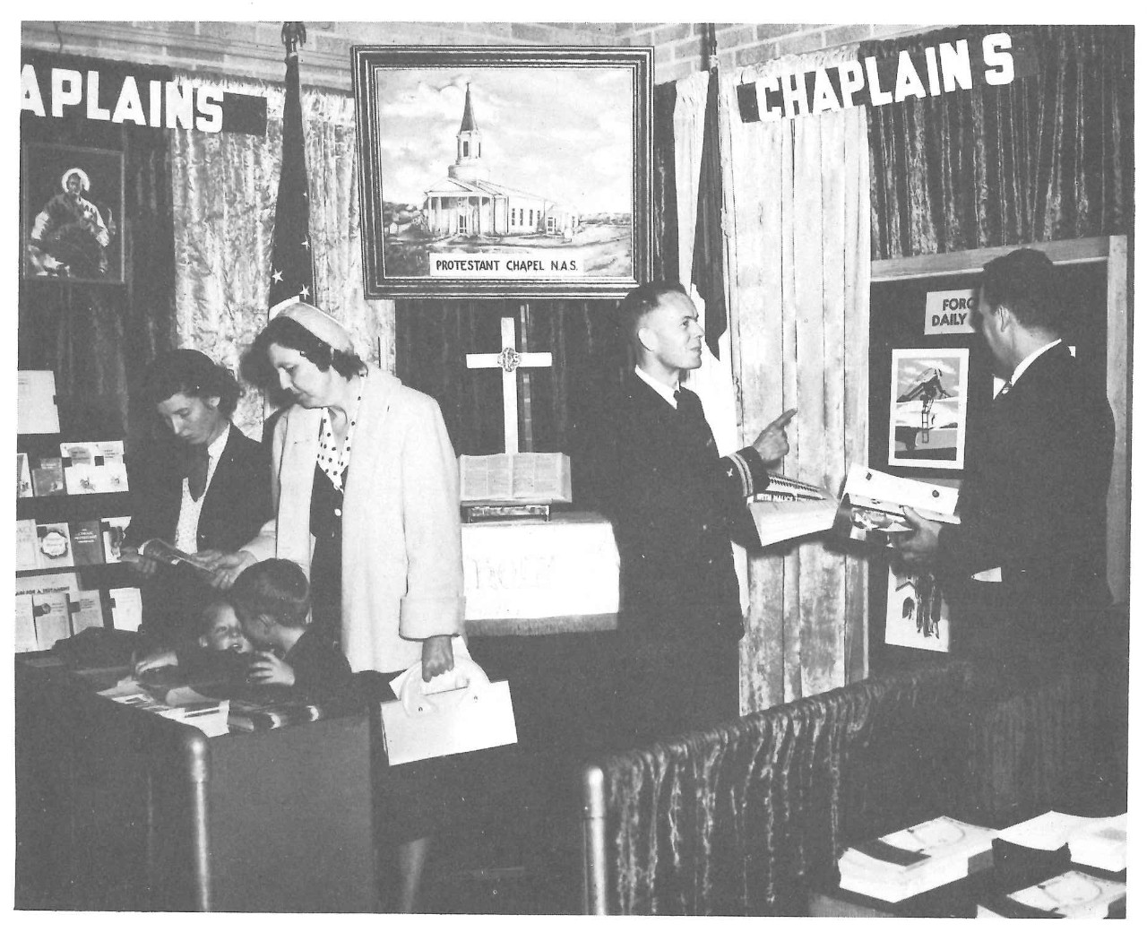 Women, children, and men near an information booth