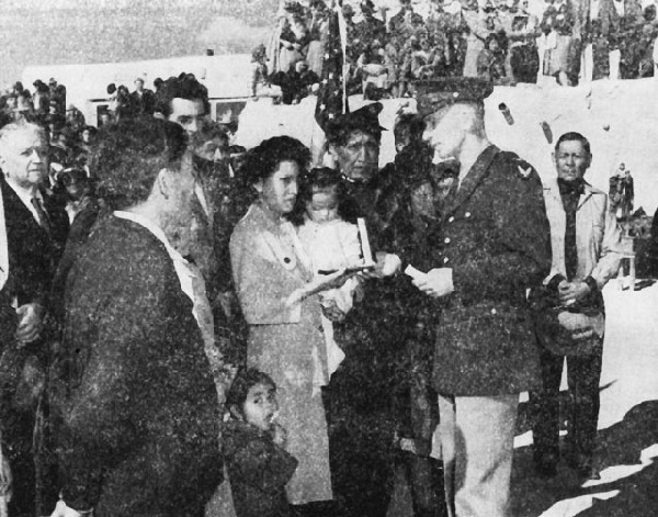 Image: In a formal ceremony at Laguna Pueblo, Mrs. Frank Paisano, Jr., accepts the Air Medal awarded to her husband, a prisoner of war in Germany. Lt. Paisano was later released and returned home. Official Photo U.S.A.A.F. 