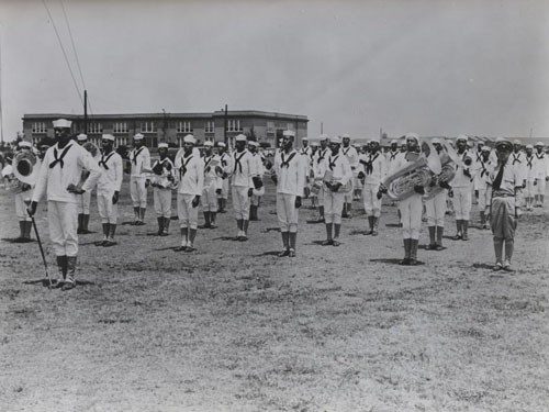 "'All Negro Band for Navy' - One of the first all-Negro bands in the history of the United States Navy is undergoing instruction at the Norfolk (Virginia) Naval Training Station. The Negro musicians, shown here in formation at Norfolk, soon will report to the University of North Carolina at Chapel Hill to act as the official band for the Navy's Preflight Training School there."