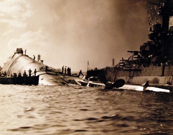 80-G-32741:   Japanese Attack on Pearl Harbor, December 7, 1941.   The capsized USS Oklahoma (BB 37) and USS Maryland (BB 46) are shown after the attack. Official U.S. Navy photograph, now in the collections of the National Archives. (9/9/2015).