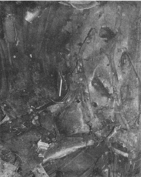 KILLEN (DD593). Looking forward and to starboard from the approximate point that the bomb detonated. Note powder can stowage racks in A-408-M. Demolished door is 4-38. Through the hole in the deck the 40mm magazine A-505-M can be seen.