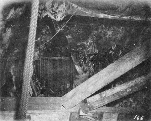 KILLEN (DD593). Damage to refrigerated spaces below second platform looking down and aft from frame 34 at second platform. The shoring in the foreground supported the temporary shell patch shown in Photo 10-1.
