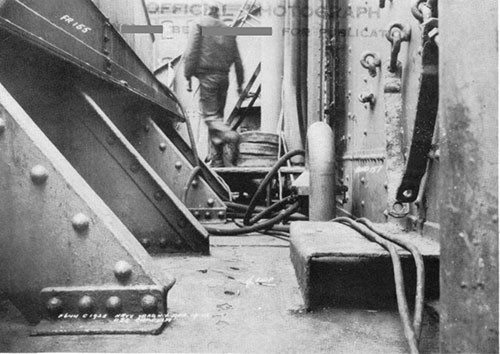 Photo 12: Main deck, looking athwartships to starboard, at frame 156. Note bulge in main deck caused by punching action of centerline stanchion shown in preceding two photographs. (U.S.S. CAPELLA).