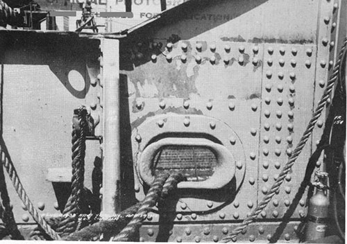 Photo 14: Damage to starboard bulwark at after end of after well deck. Note strained plating and crack in fair-lead. (U.S.S. CAPELLA).