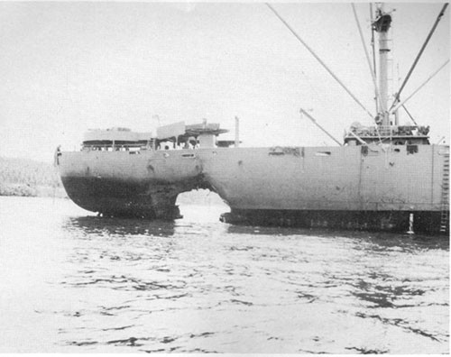 Photo 19: Torpedo damage to starboard shell. Note abrupt cutting-off damage by full peak tank just aft of rupture. Also note sag of stern. (U.S.S. ALHENA).